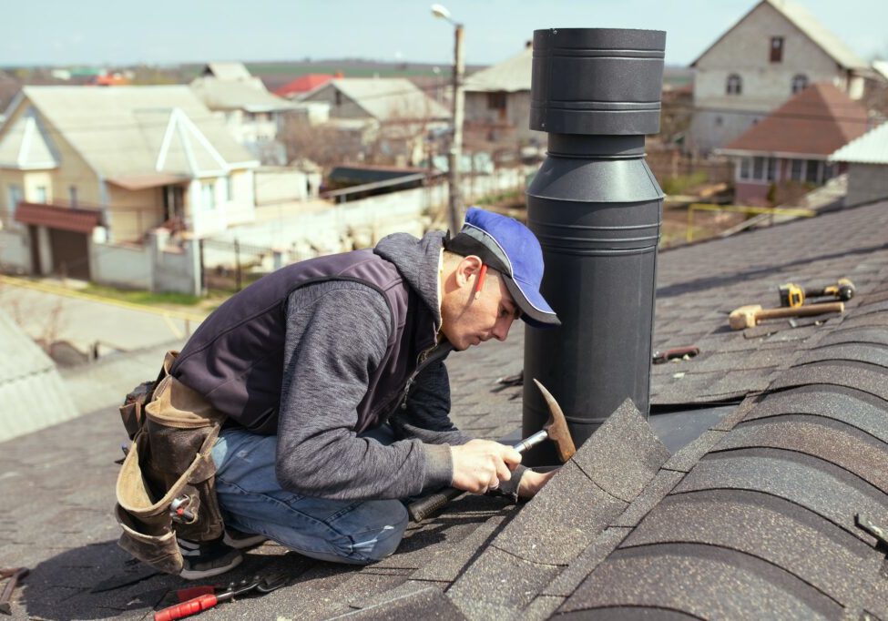 a professional master (roofer) with hammer repairs the roof.